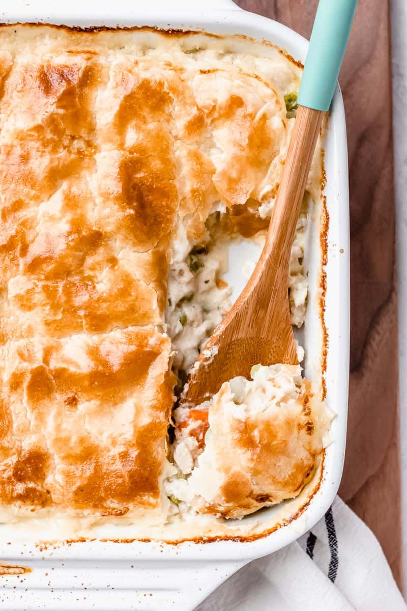 Close up of chicken pot pie with a scoop of pie on a wood spoon