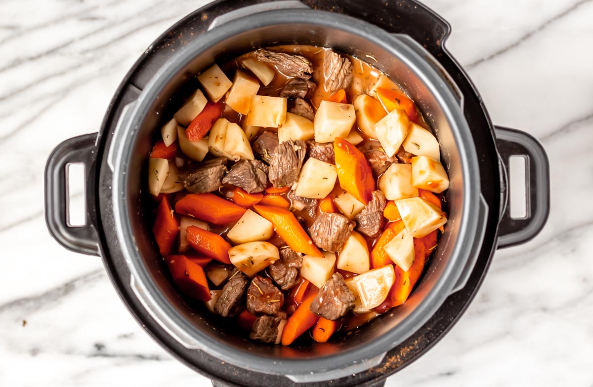 Beef and vegetables inside of an Instant Pot.