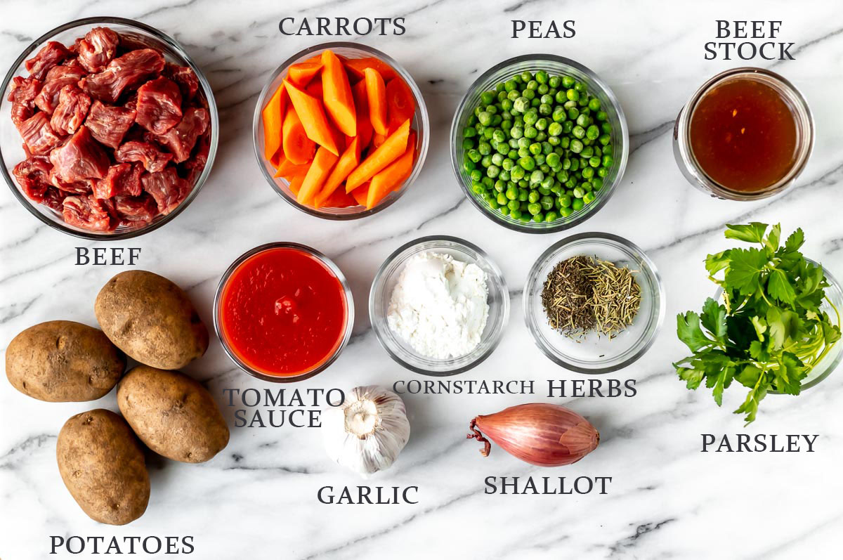 Ingredients needed to make beef stew in the Instant Pot on a marble background with text overlay.