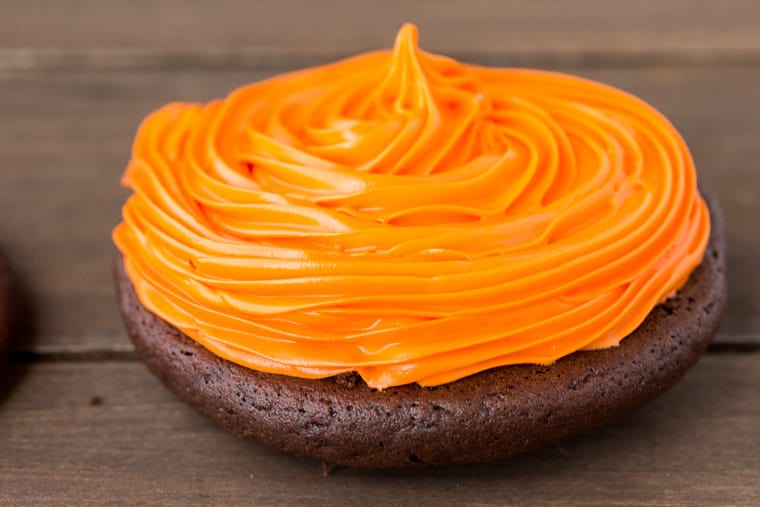 Orange Cake Icing Piped onto a Whoopie Pie on a wood table