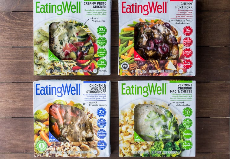 4 EatingWell Frozen Meals on a Wood Back Drop