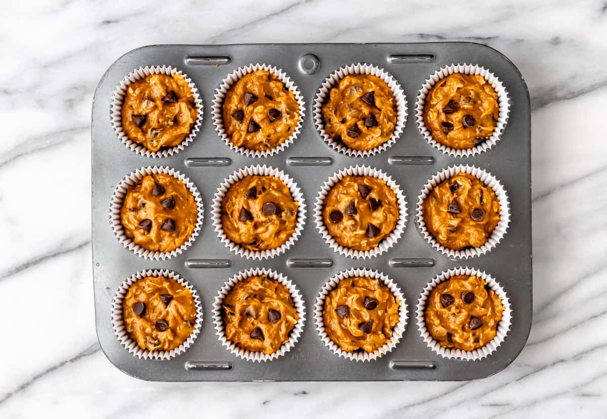 Pumpkin chocolate chip muffin batter in a muffin tin prior to baking.