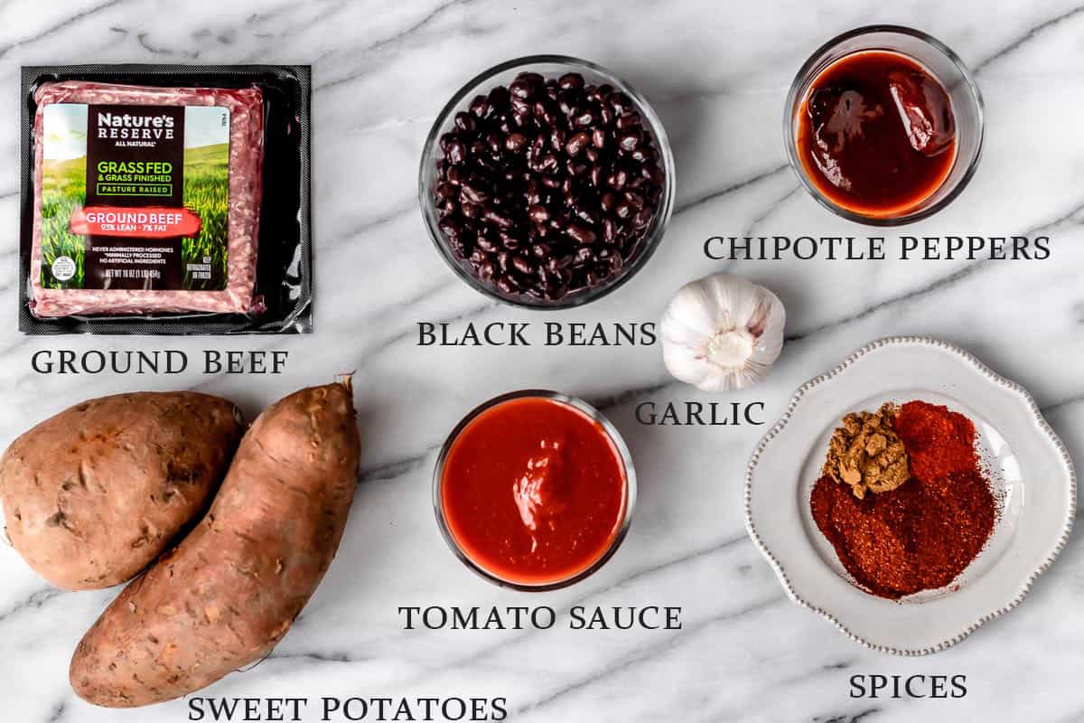 Ingredients to make sweet potato chili on a marble background with text overlay.