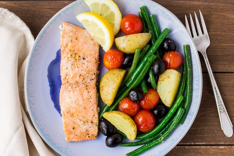 Baked Salmon and Vegetables on a Blue Plate with a Beige Napkin and Fork