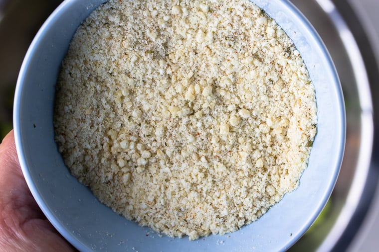 Parmesan bread crumbs in a light blue bowl close up