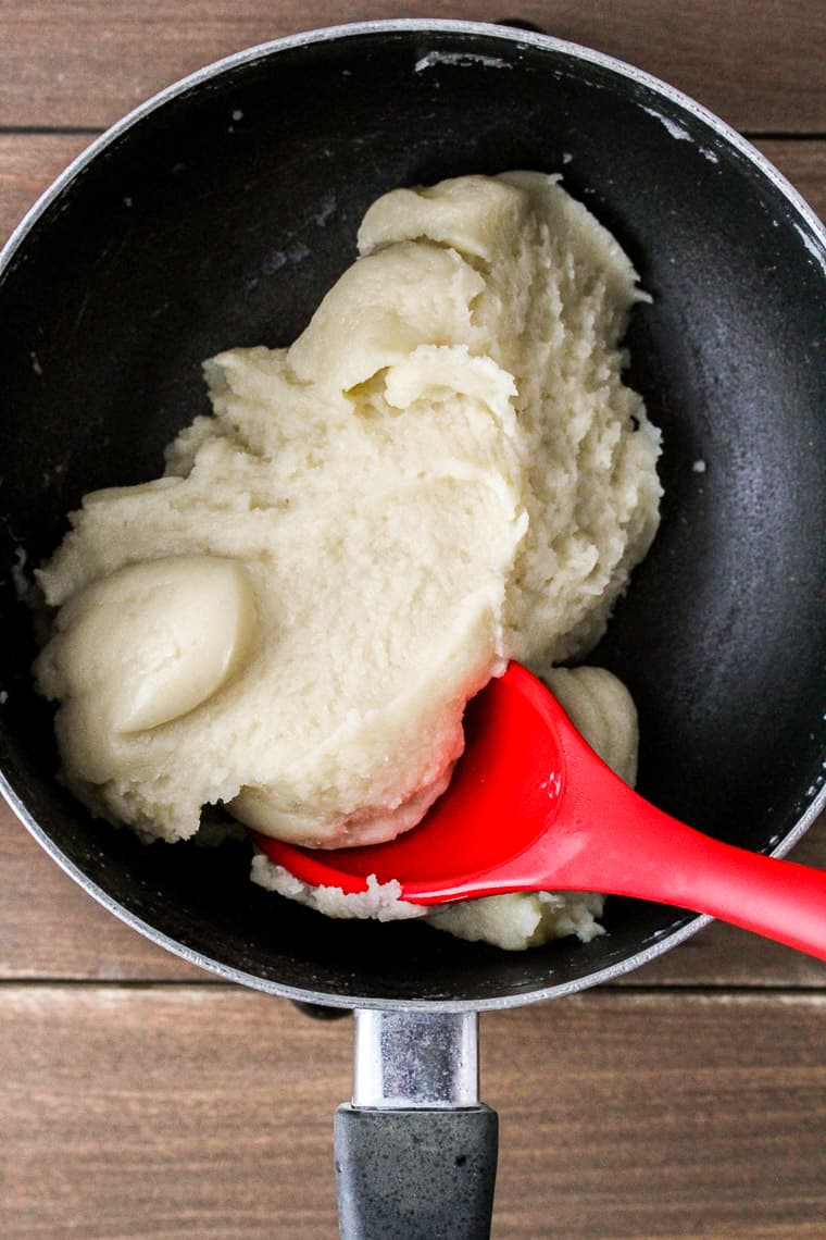 Cream Puffs Pastry in a Sauce Pan with a Red Silicone Spoon