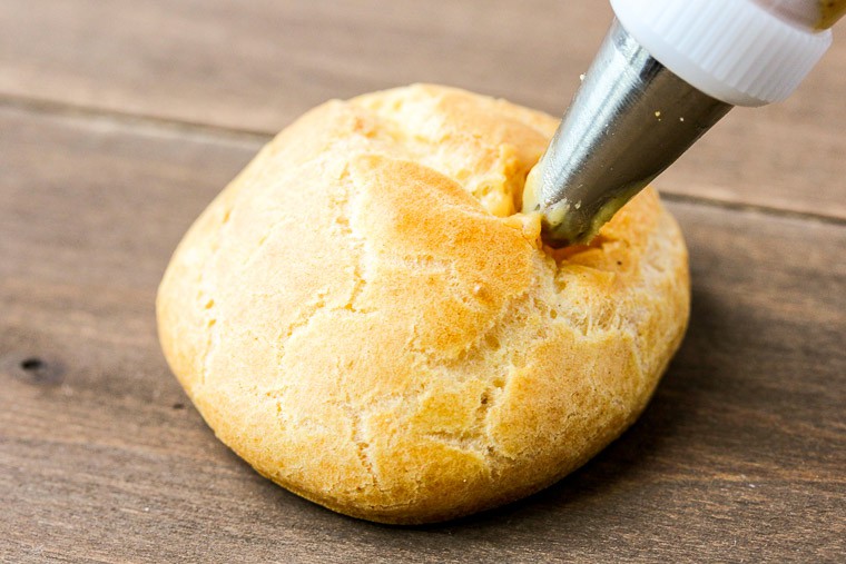 A Piping Tip Inserted into a Small Hole in a Cream Puff