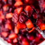 Cranberry Apple Chutney in a White Serving Bowl with a Spoonful Above It