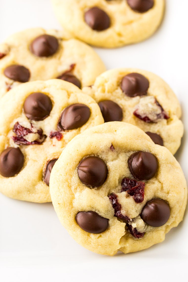 Dark Chocolate Chip Cranberry Cookies stacked on a white background