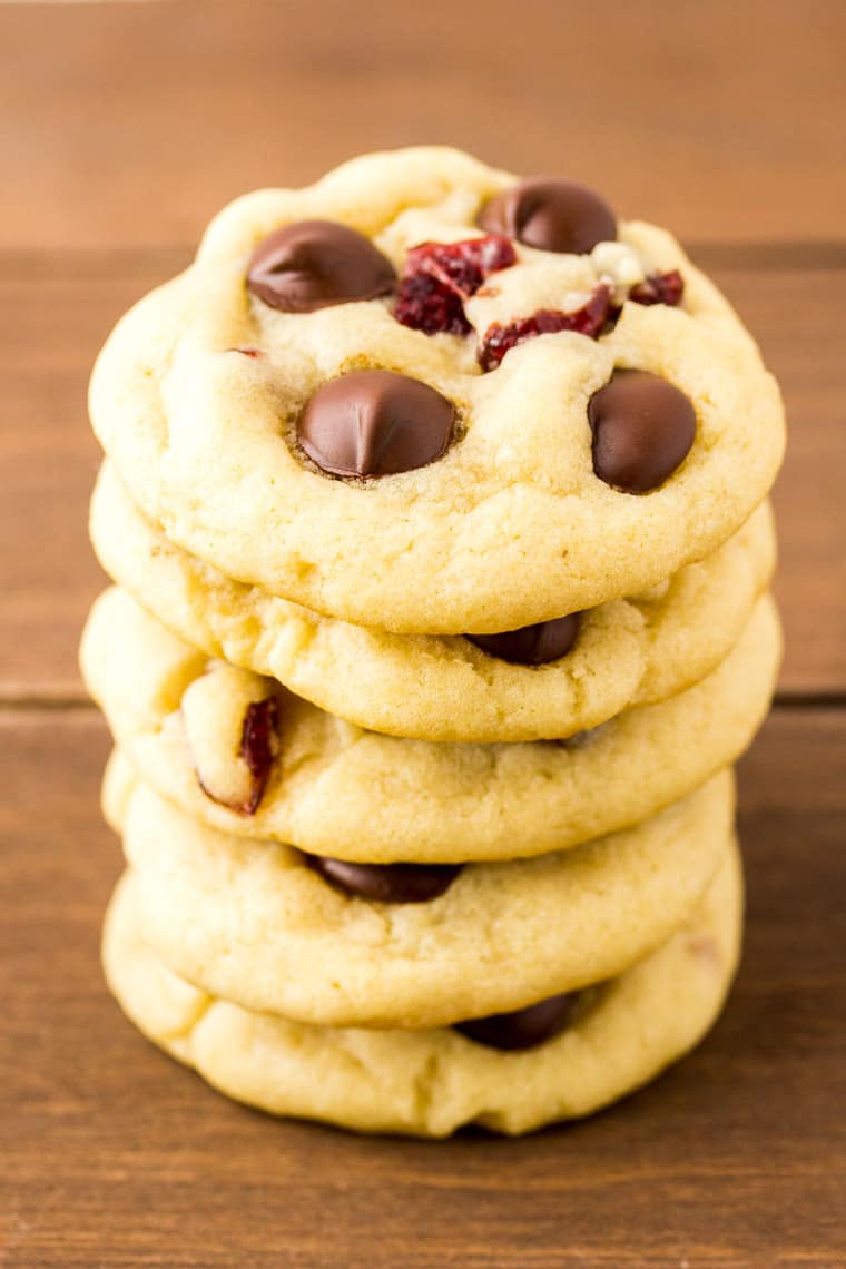 A Stack of Dark Chocolate Cranberry Cookies on a wood backdrop