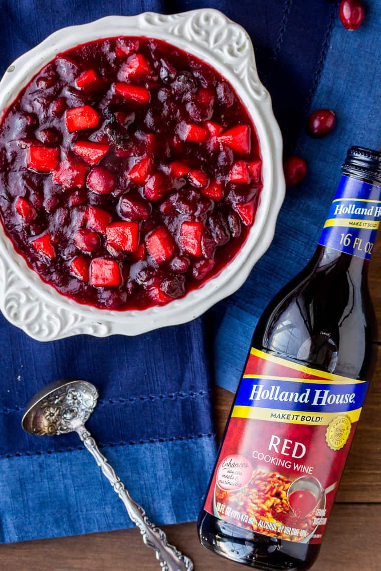 Cranberry Apple Chutney in a White Bowl with a Blue Napkin and Bottle of Cooking Wine