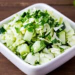 Keto Avocado Cabbage Slaw in a White Serving Dish with Cilantro and Lime