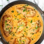 Sweet chili coconut chicken in a skillet with more chicken and sauce all around it and text overlay.