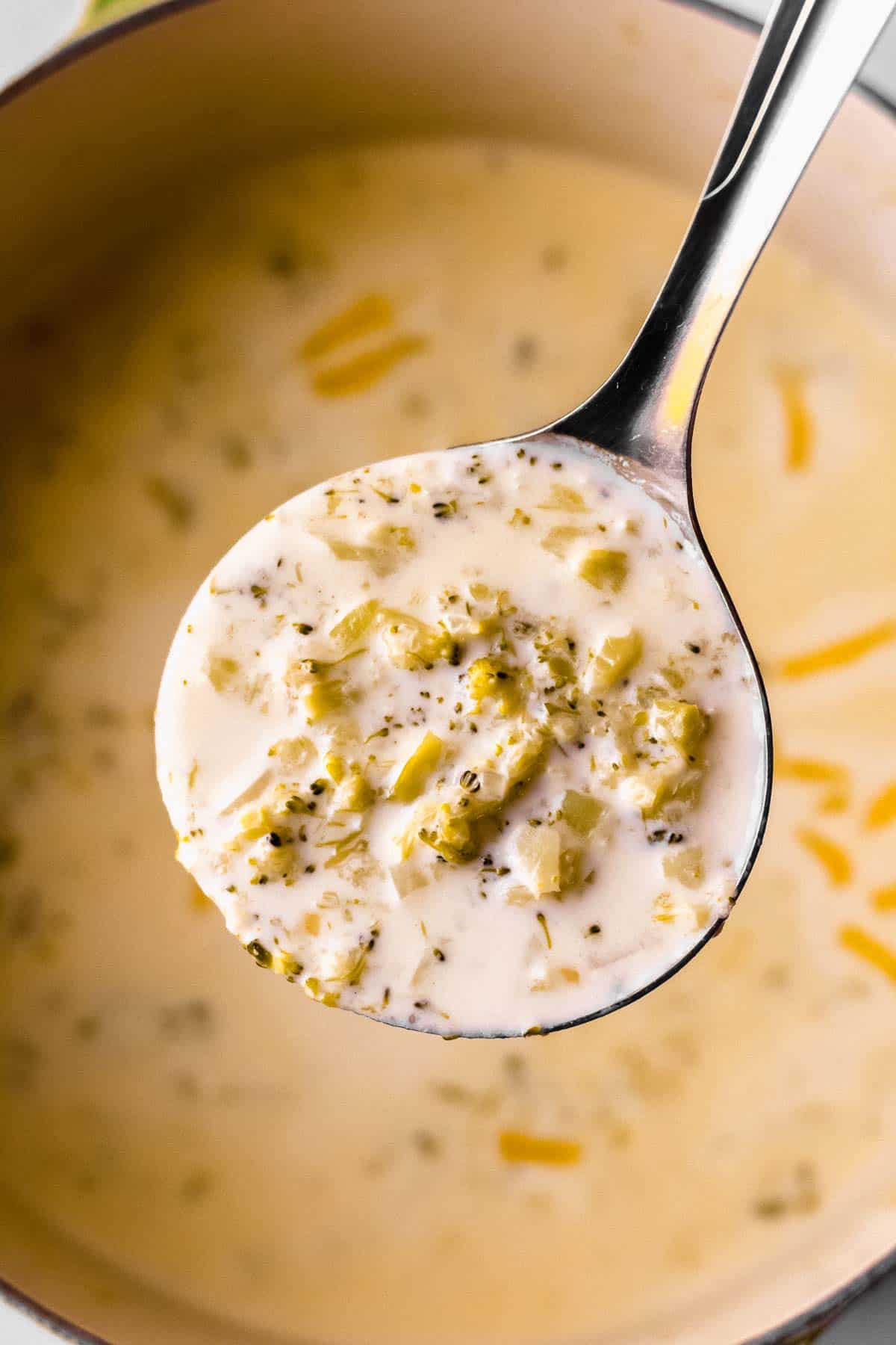 A close up of a ladle full of Keto Broccoli Cheese Soup