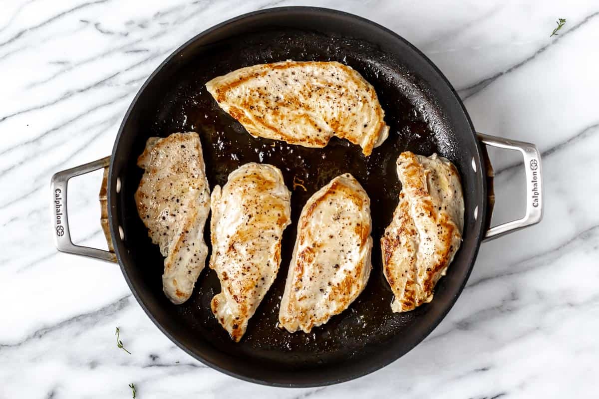 5 cooked chicken breasts in a skillet.