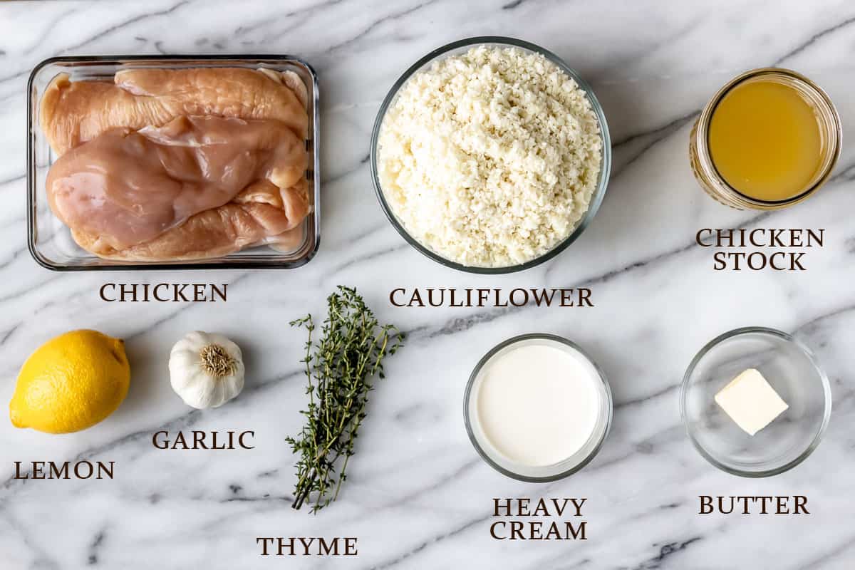 Ingredients to make skillet lemon chicken with cauliflower rice on a marble background with text overlay.