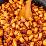 Maple Bacon Sweet Potato Hash in a cast iron skillet with a wood server and text overlay.