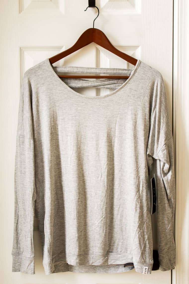 Stitch Fix Andrew Marc Performance Annwin Cut Out Knit Top on a wood hanger in front of a white door