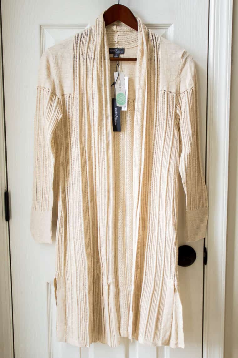 Market & Spruce Zonia Cotton Duster Cardigan in cream color from Stitch Fix hanging on a wood hanger in front of a white door