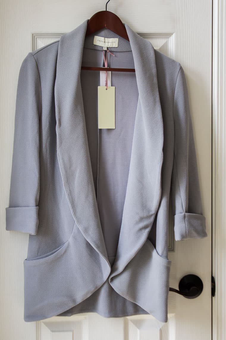 French Mauve Melanie Knit Tunic Blazer in light gray on a hanger over a white door