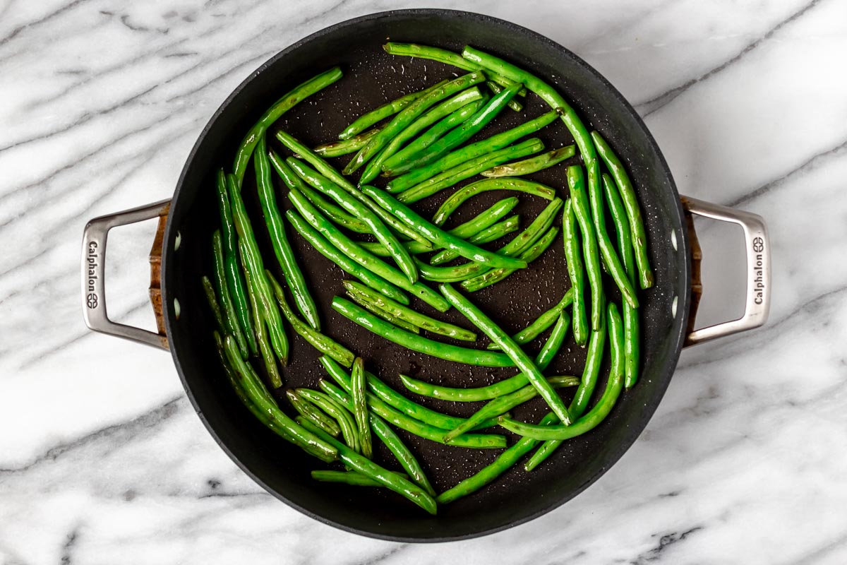 Green beans cooking in a skillet.
