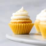 Mini Lemon Cupcakes on a cake stand with a gray background.