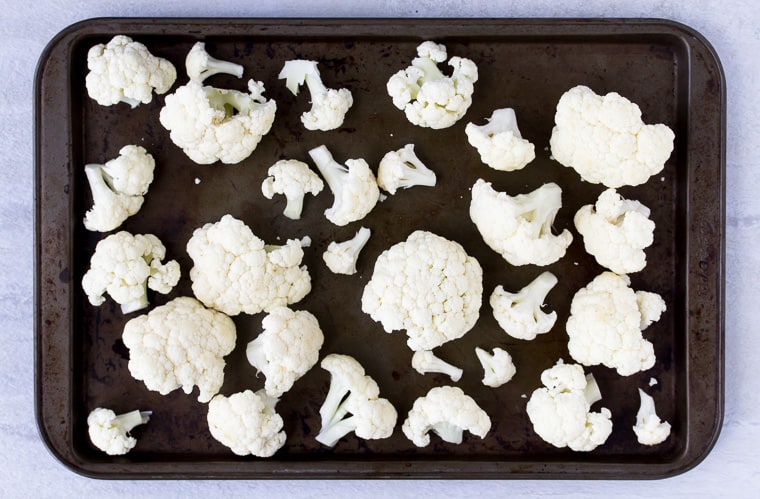 Cauliflower florets on a baking sheet before cooking