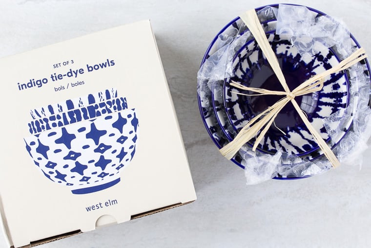 West Elm Indigo Tie Dye Bowls box with the blue and white bowls stacked next to it over a white background
