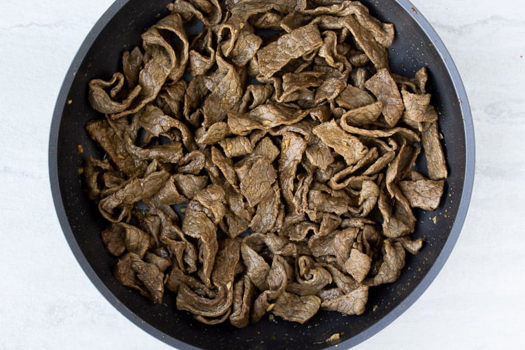 Cooked Beef Strips in a Black Skillet