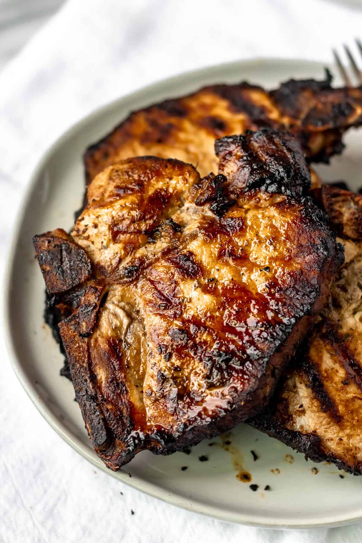 Close up of Grilled Cuban Pork Chops on a white plate.