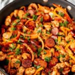 Close up of a black skillet filled with keto jambalaya with text overlay.