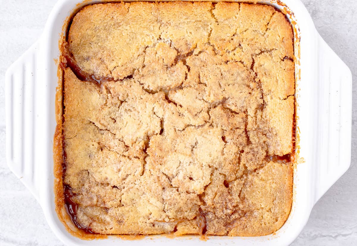 Baked peach cobbler in a white, square baking dish