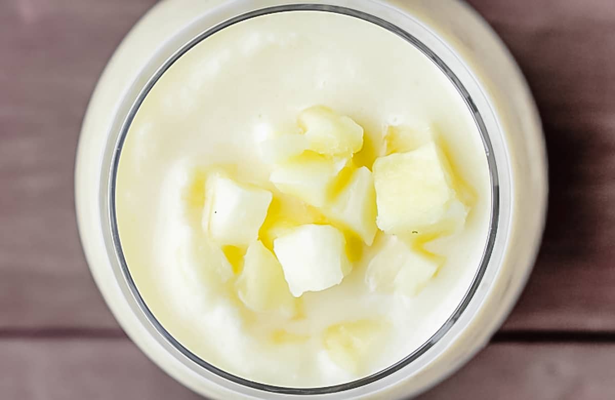 Overhead of a pineapple lemon smoothie with chunks of pineapple on top