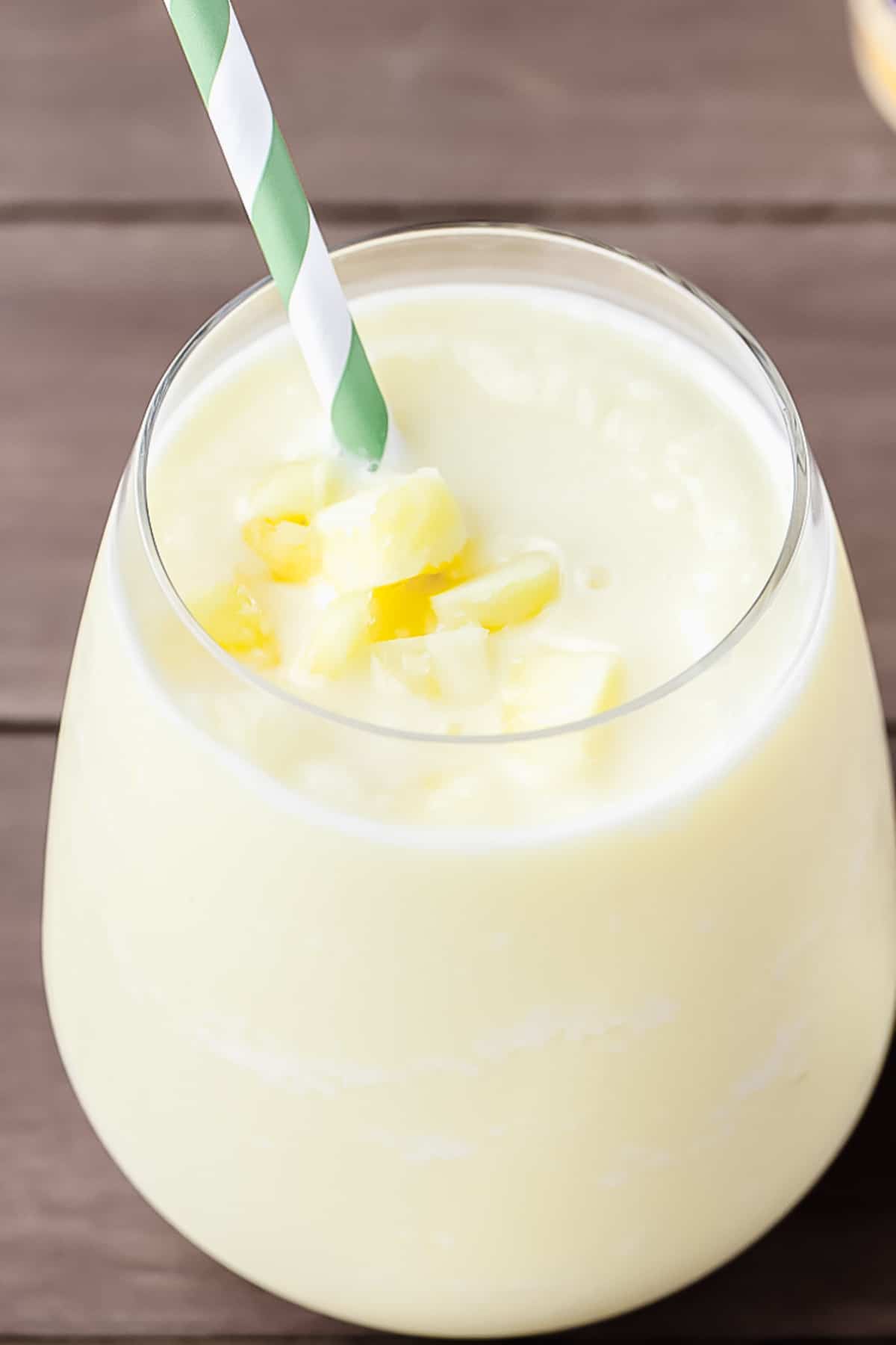 Pineapple Lemon Smoothie in a glass with a straw