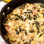 Close up of a skillet of spinach artichoke chicken with text overlay.