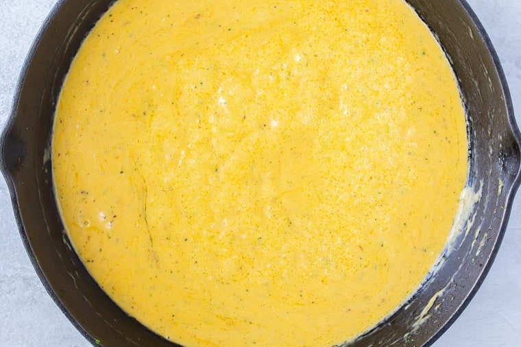 Cheese sauce cooking in a black skillet