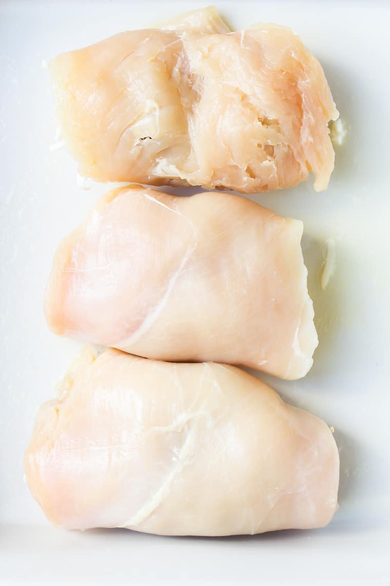 Three rolled up chicken breasts in a white baking dish