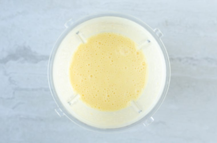 Overhead view of egg bite mixture over a white backdrop