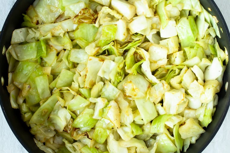 Cooked chopped cabbage in a black skillet