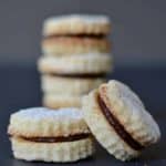 Vegan Chocolate Coconut Cookies stacked on top of each other with a gray background