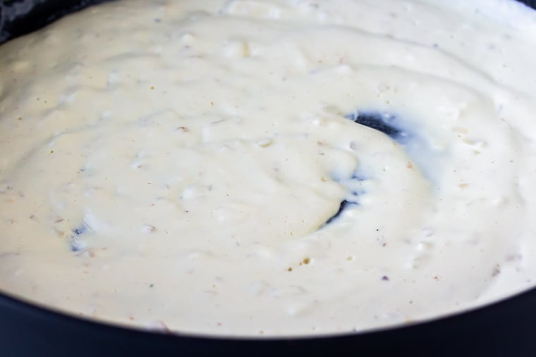Close up of cream cheese sauce in a black skillet