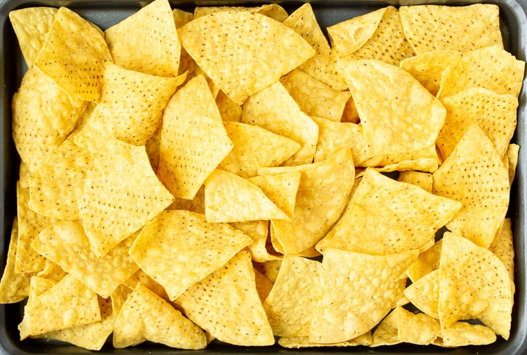 A sheet pan filled with bare nacho chips