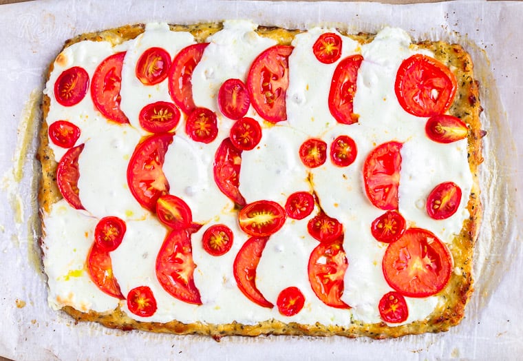 Fresh tomatoes and melted mozzarella cheese on a rectangular pizza crust