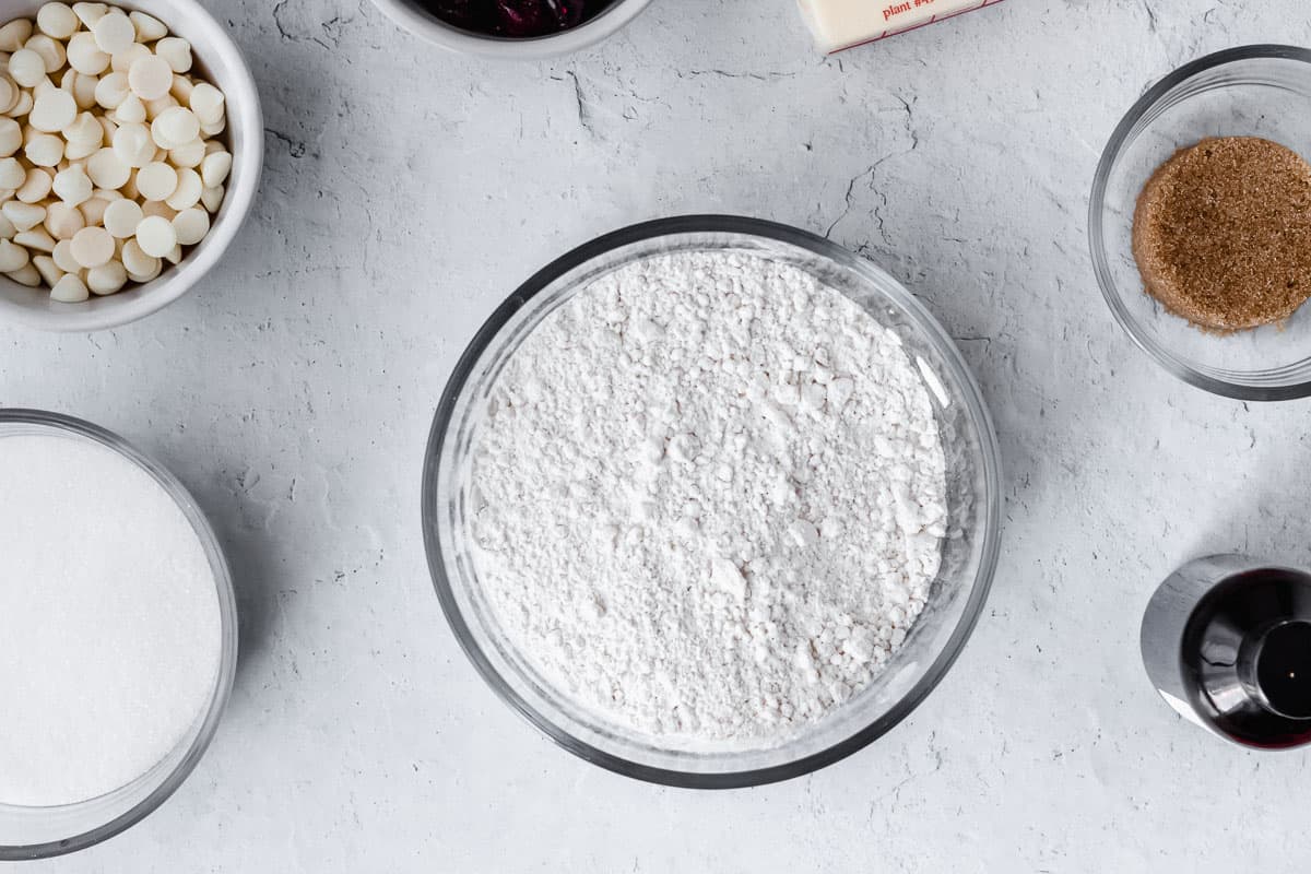 Flour mixture in a glass bowl with other ingredients around it