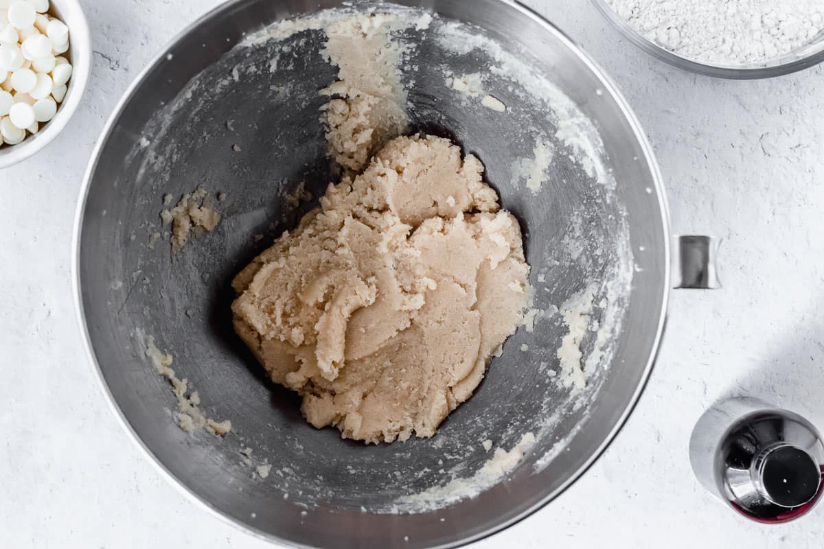 Butter, brown sugar, and sugar creamed together in a silver mixing bowl