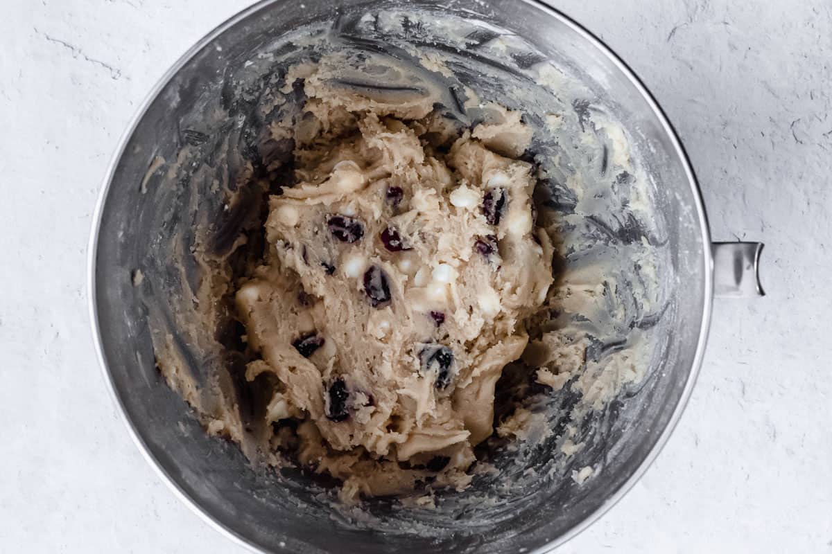 White chocolate chip cranberry cookie dough in a silver mixing bowl