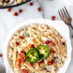 Jalapeno popper chicken pasta in a white bowl with text overlay.