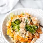 A keto chicken divan casserole with a wood server in it and text overlay.