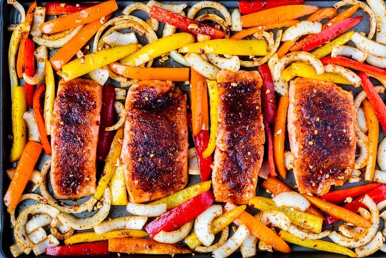 Salmon, peppers and onions on a sheet pan ready to be baked
