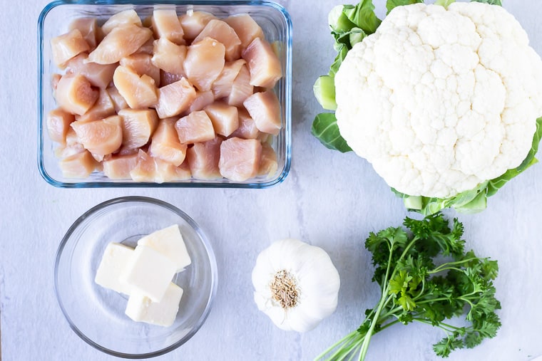 Ingredients needed to make Garlic Butter Chicken on a white background
